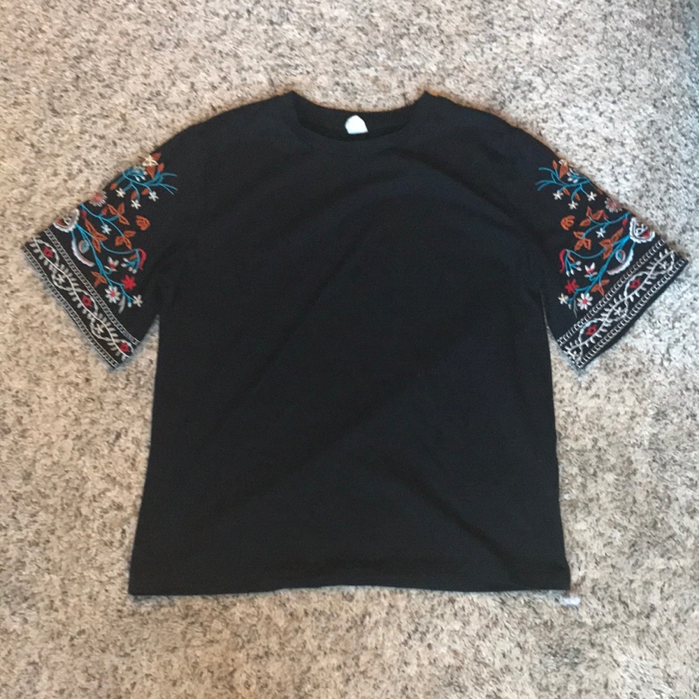 Black T-shirt with floral sleeves.